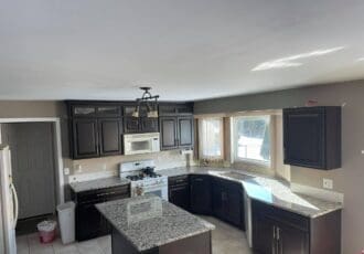 remodeled kitchen, black cabinets with gray and black countertops