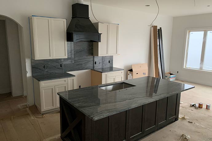 Kitchen remodel in progress with black quartzite countertops
